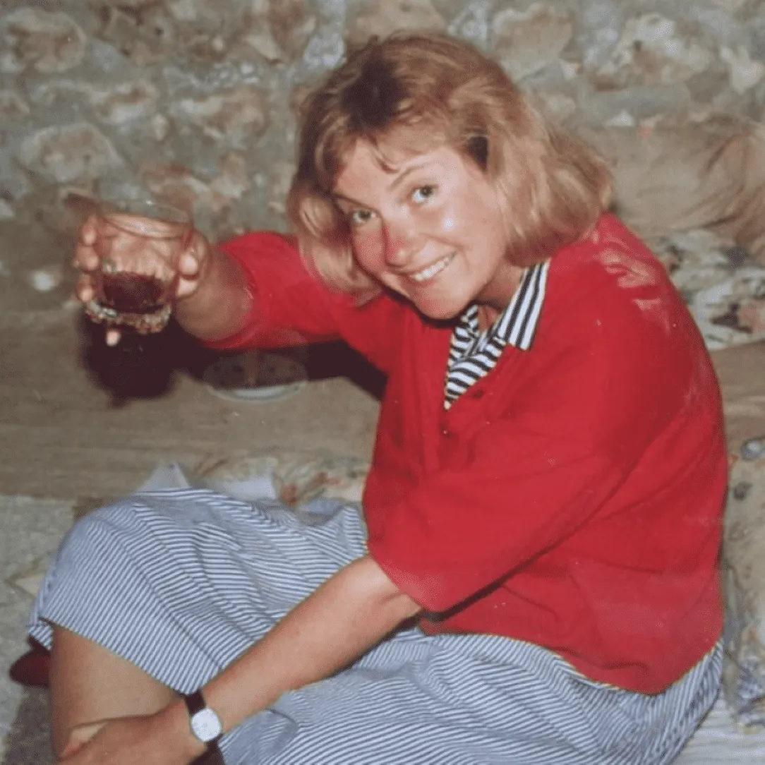 Judith Holder holding up a drink to raise a toast.