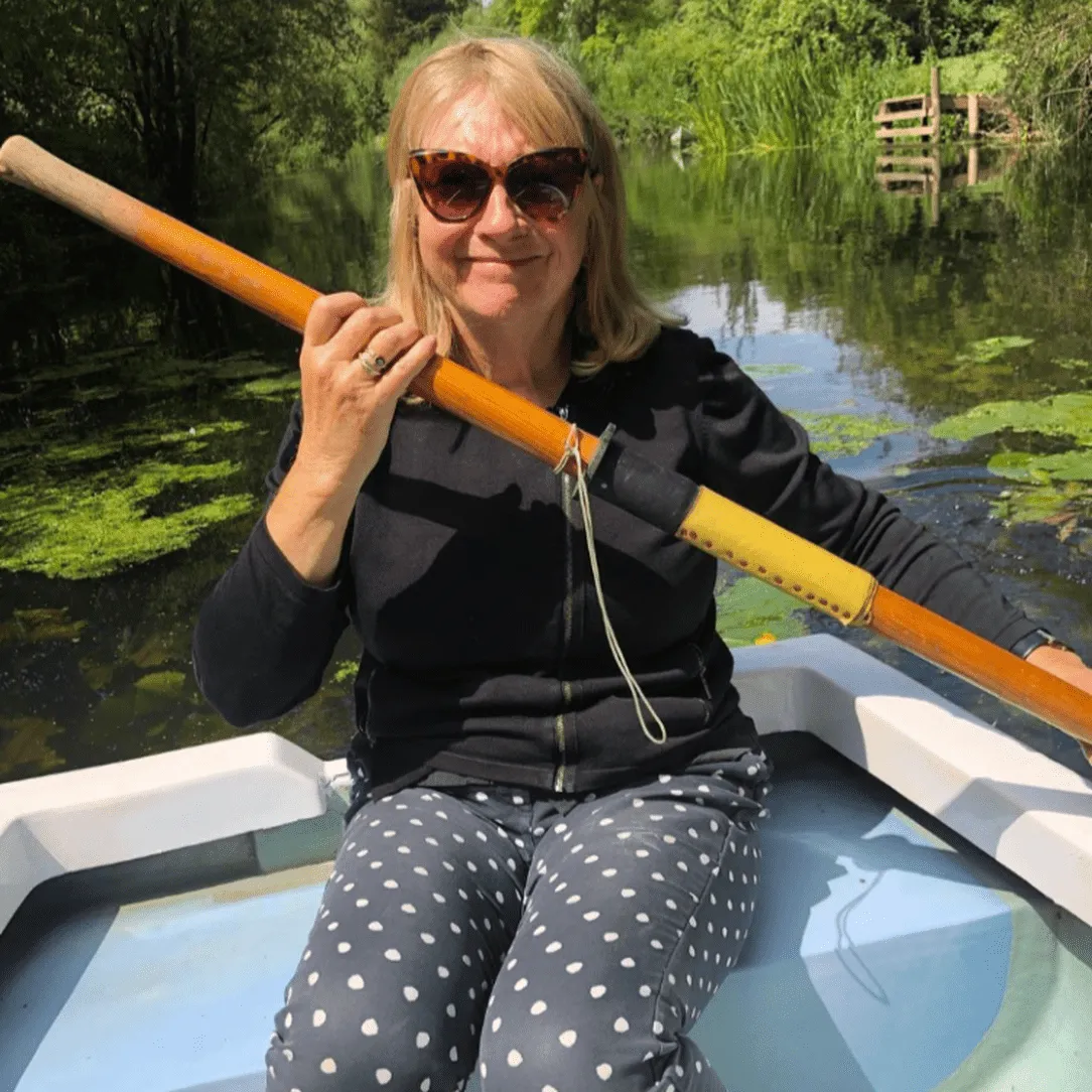 Judith Holder sitting in a boat and holding an oar.